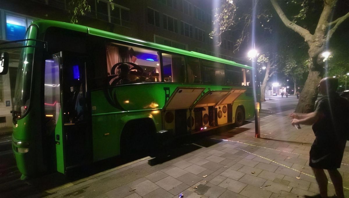 The bus lit up green at night